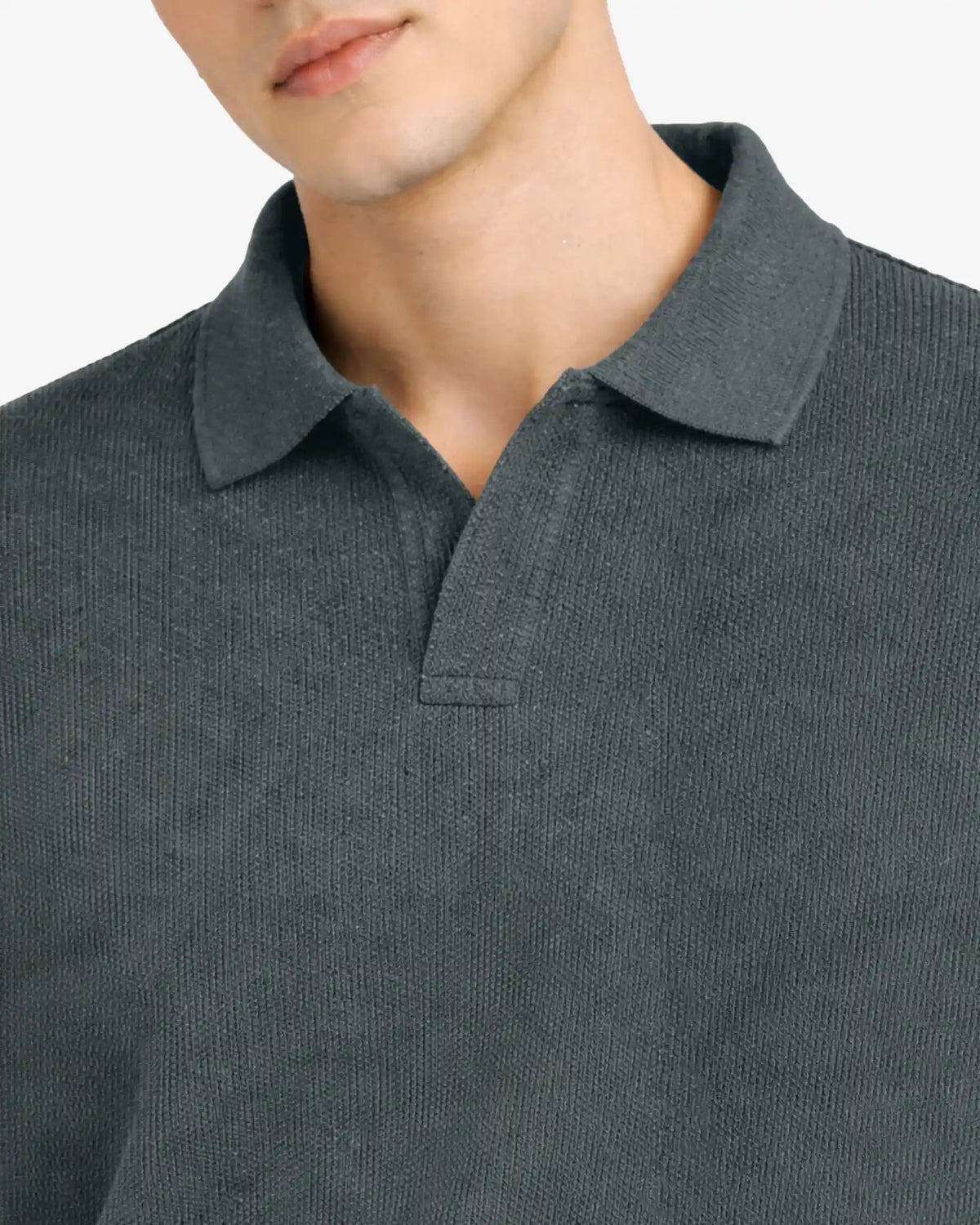 Close-up of a person wearing a dark gray polo shirt with a plain background