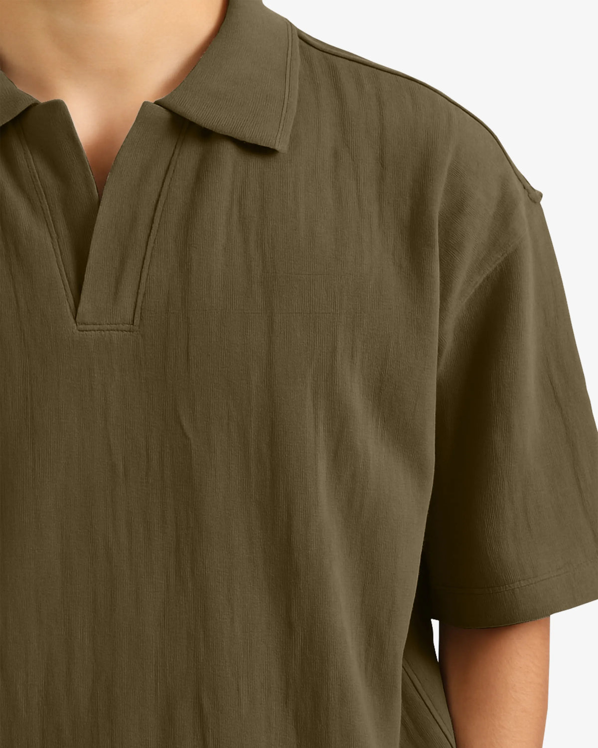Close-up of a person wearing an olive green polo shirt on a white background
