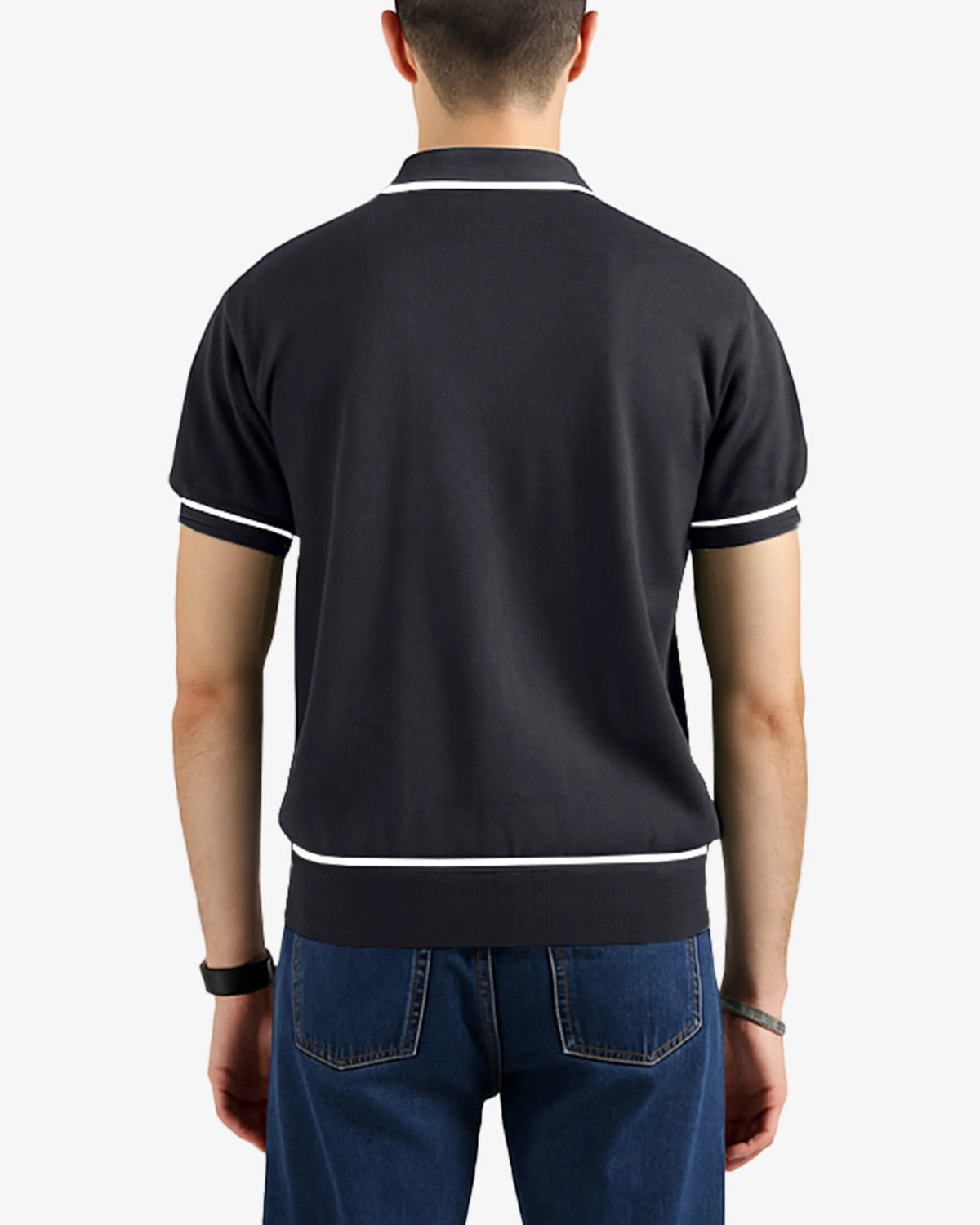 Person wearing a black polo shirt with white trim on a plain background