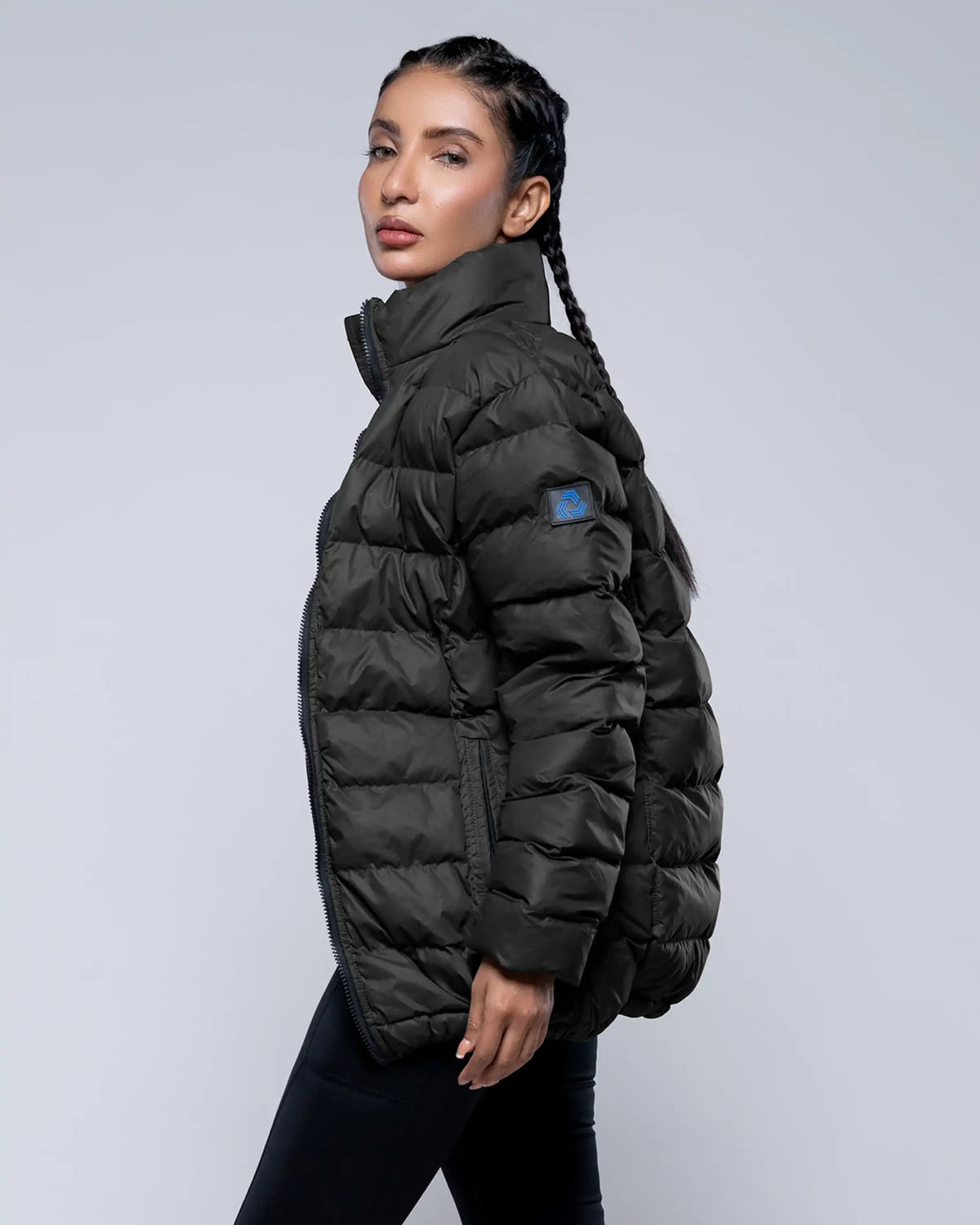 Woman wearing a black puffer jacket on a light gray background
