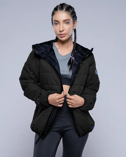 Woman wearing a black puffer jacket on a gray background