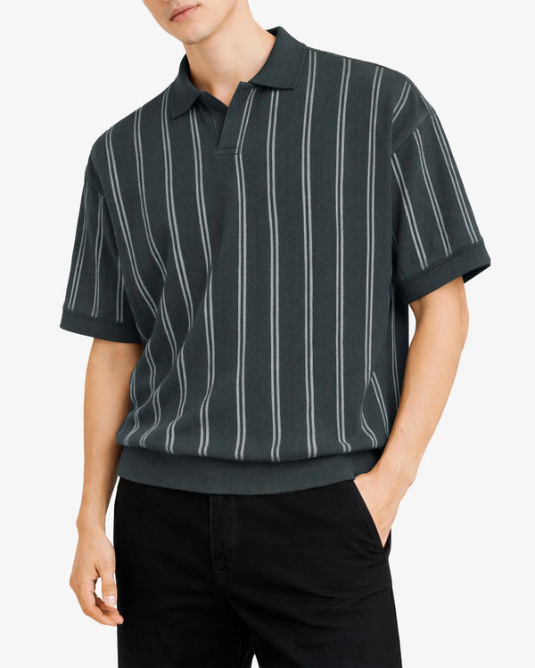 Man wearing a black and white striped polo shirt on a white background