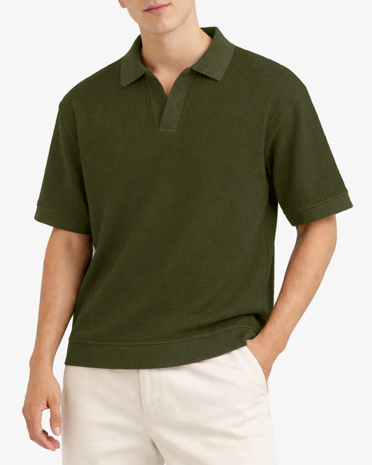 Person wearing a green polo shirt and white pants on a light gray background