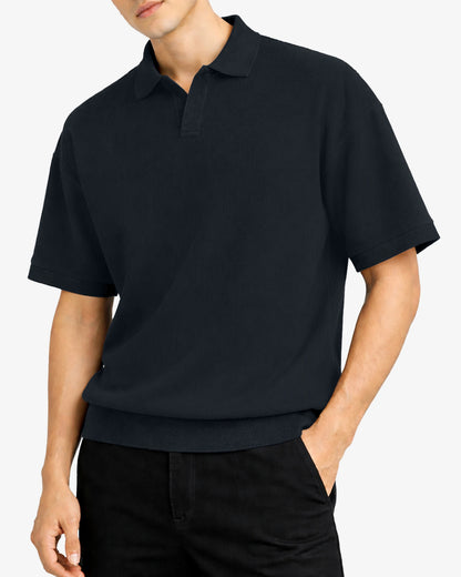 Person wearing a black polo shirt against a white background