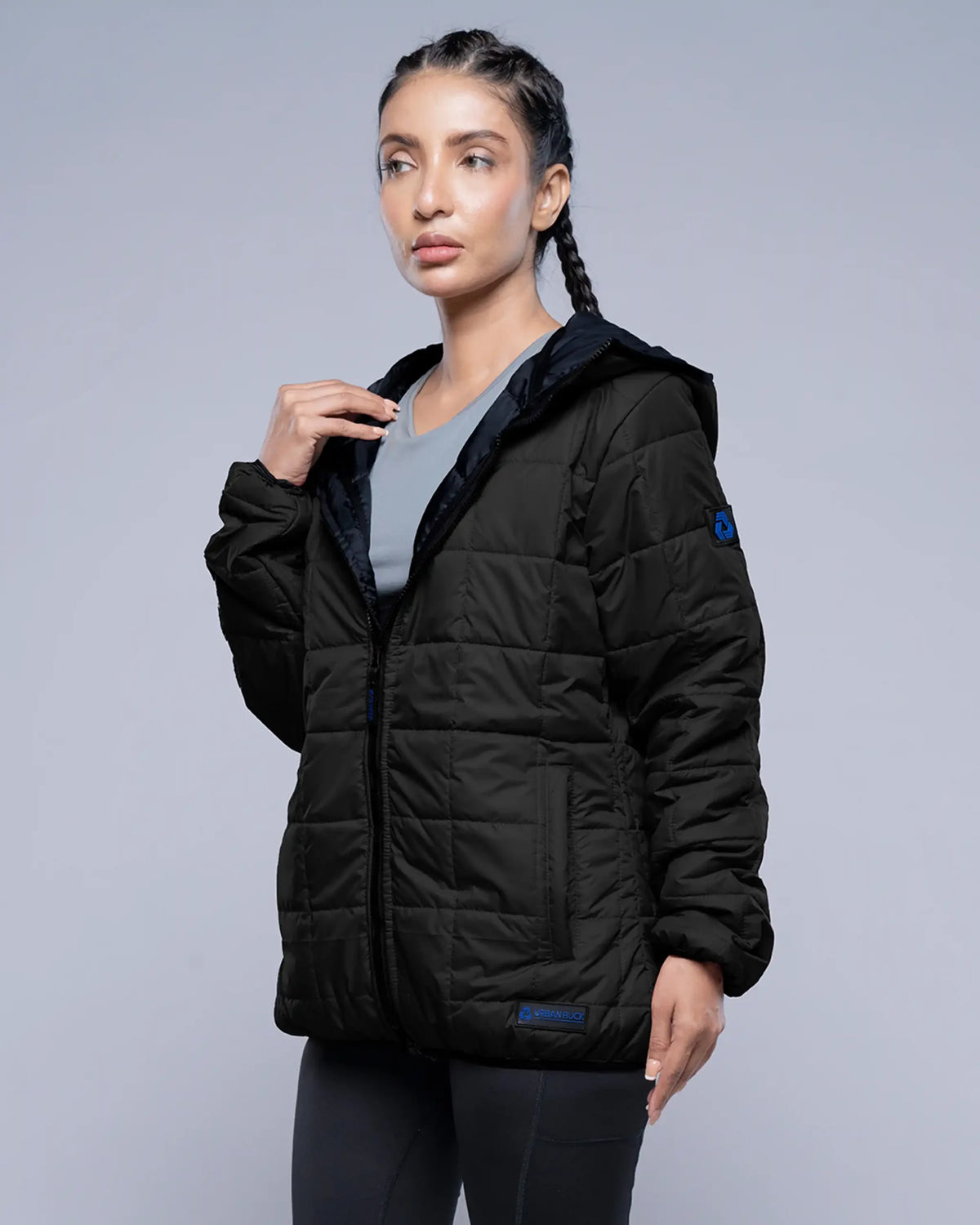 Woman wearing a black puffer jacket on a gray background