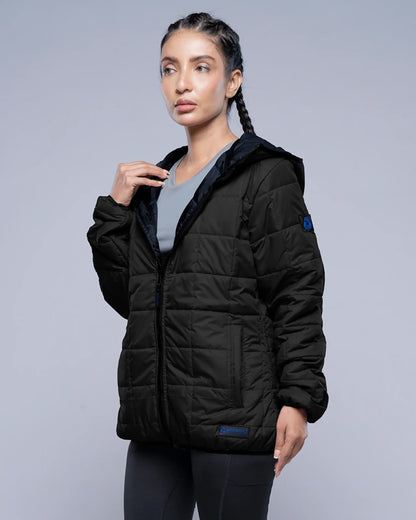 Woman wearing a black puffer jacket on a gray background
