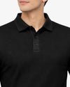 Black textured polo shirt worn by a person on a white background