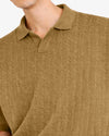 Close-up of a person wearing a brown knitted sweater with a collar.
