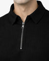 Close-up of a black quarter-zip garment with a zipper detail.