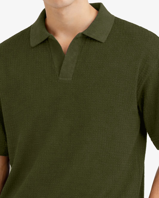 Green polo shirt worn by a person on a white background