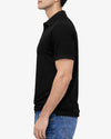 Person wearing a black polo shirt and blue jeans on a white background