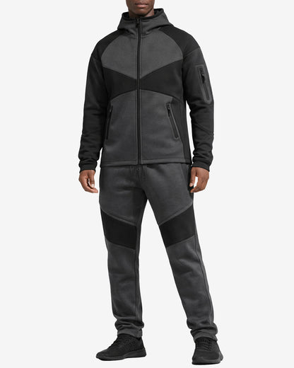Person wearing a black and gray tracksuit on a white background