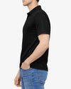 Person wearing a black polo shirt and blue jeans on a white background