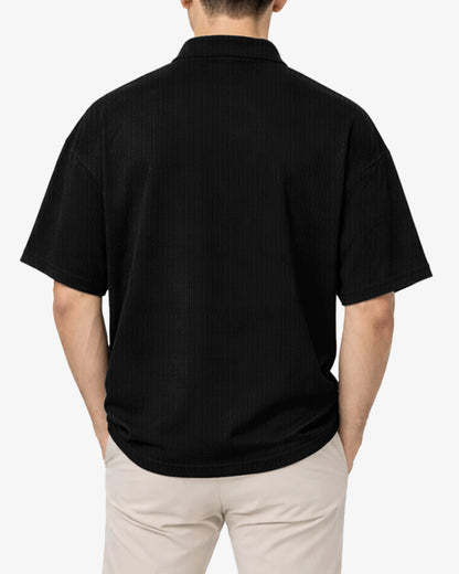 Person wearing a black polo shirt on a white background