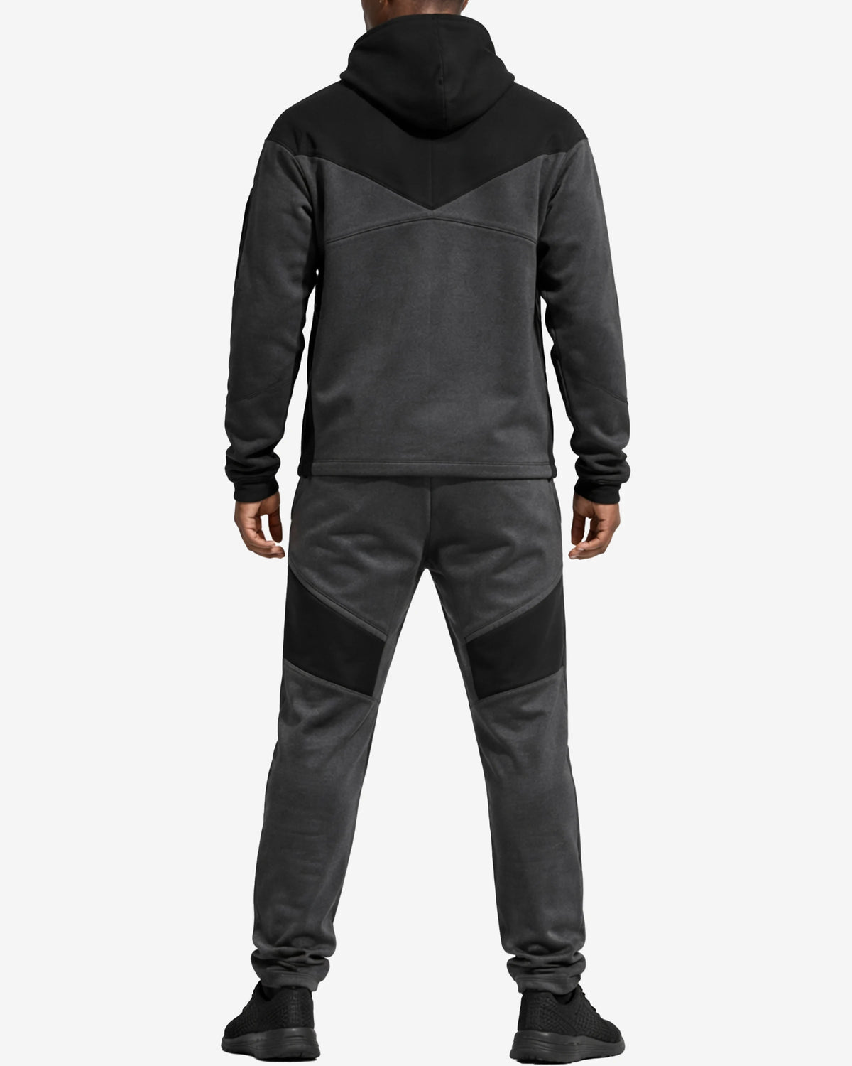 Person wearing a gray and black tracksuit on a white background