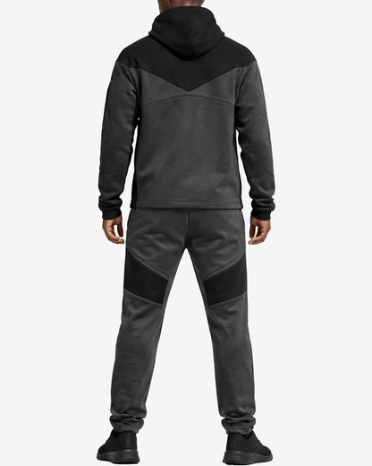 Person wearing a gray and black tracksuit on a white background