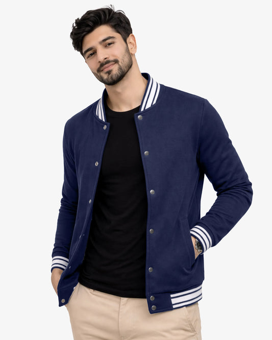Man wearing a navy blue varsity jacket with white accents on a white background