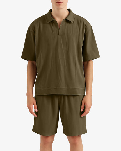 Person wearing a green polo shirt and shorts set on a white background
