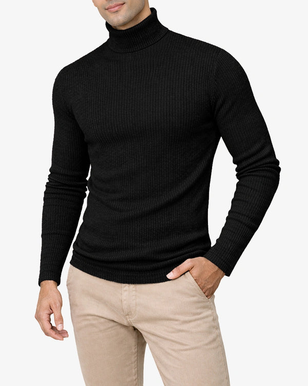 Man wearing a black turtleneck sweater and beige pants on a light gray background