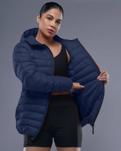 Woman wearing a blue puffer jacket against a gray background