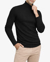 Man wearing a black turtleneck sweater and beige pants on a white background