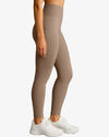 Beige leggings worn by a person on a white background