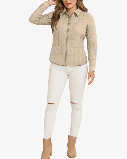 Woman wearing a beige quilted jacket and white pants on a white background