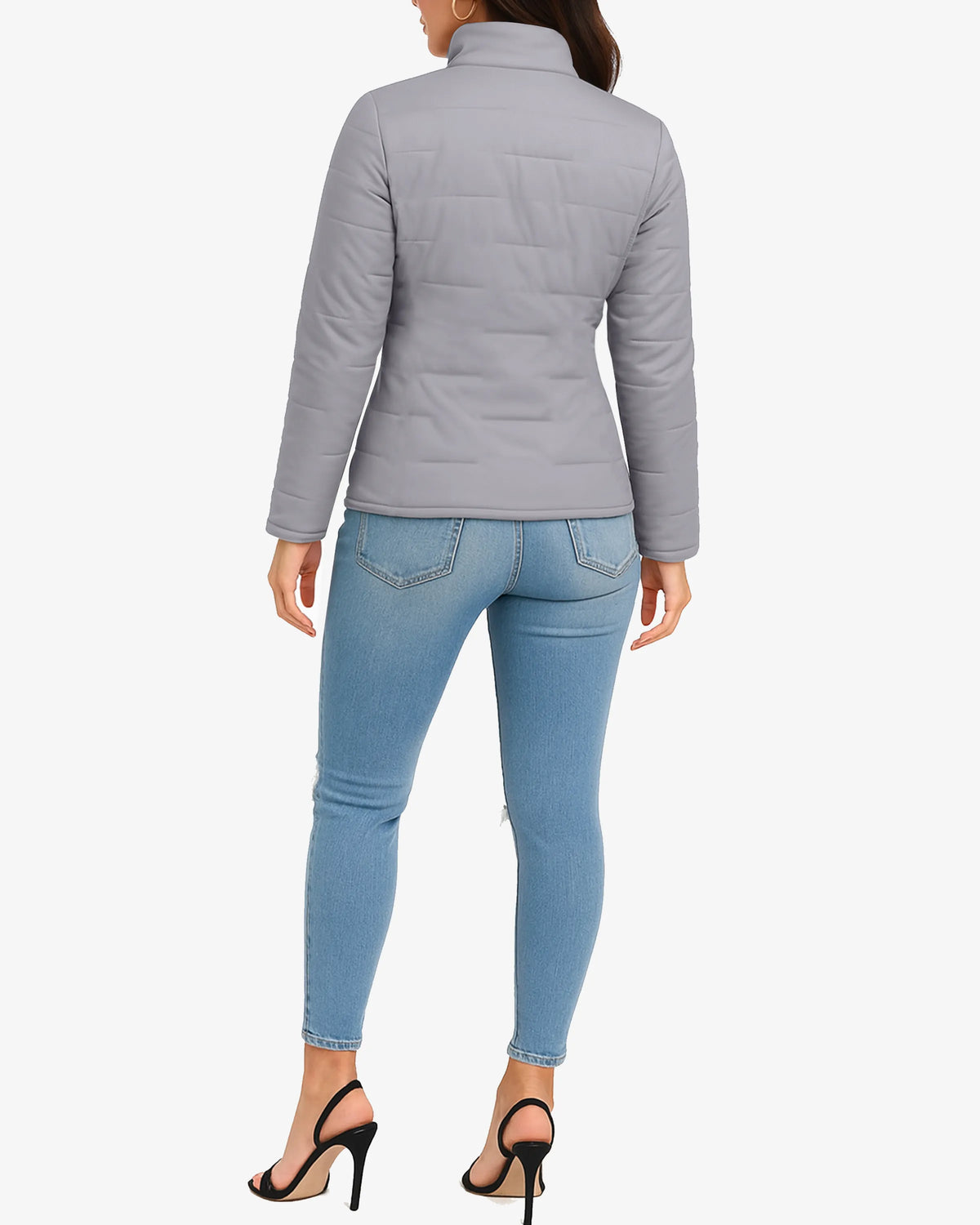 Person wearing a gray puffer jacket and light blue jeans on a white background