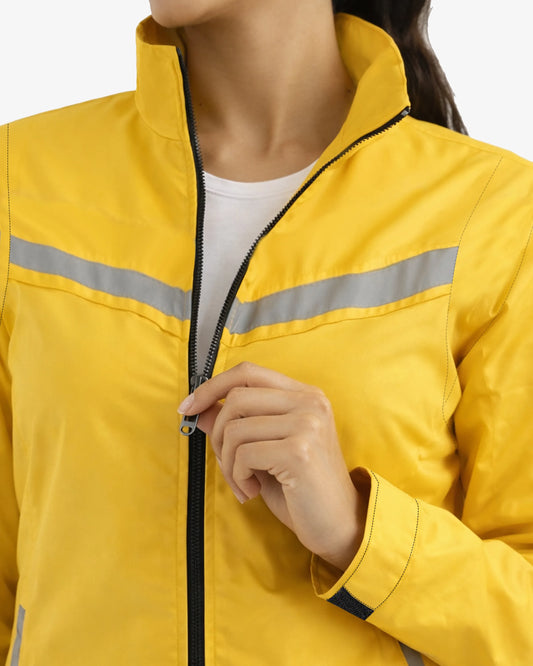 Person wearing a yellow safety jacket with reflective stripes on a white background