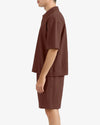 Person wearing a brown outfit on a white background