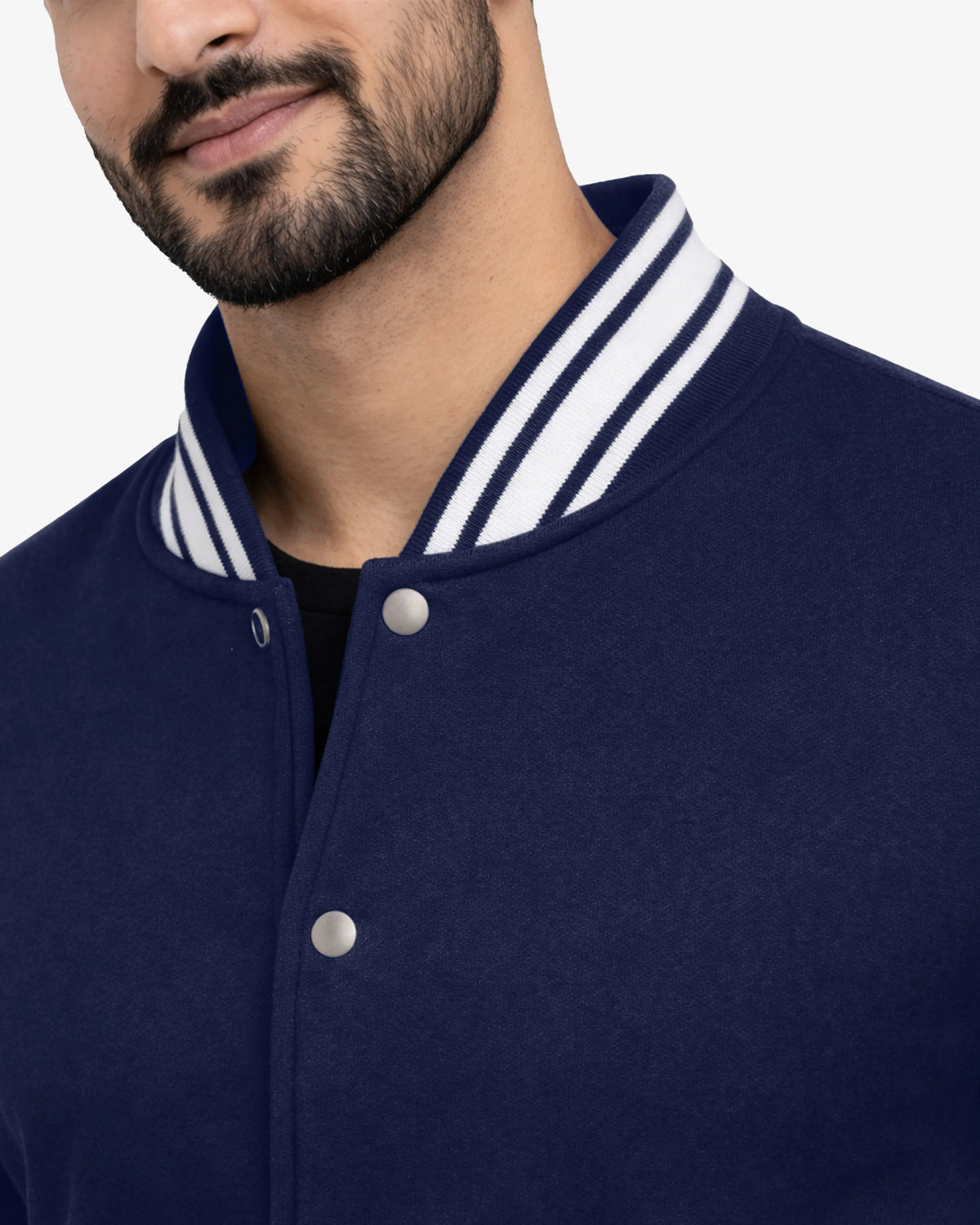 Navy blue varsity jacket with white trim worn by a person on a light gray background