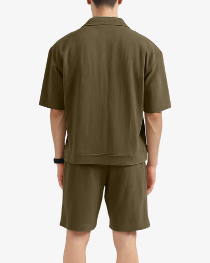 Person wearing a green polo shirt and shorts set on a white background