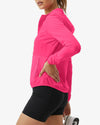 Person wearing a bright pink jacket and black shorts on a white background