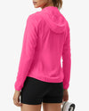 Person wearing a bright pink jacket and black shorts on a white background