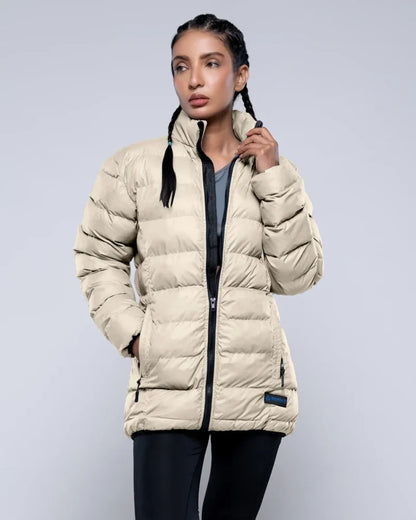 Woman wearing a beige puffer jacket on a light gray background