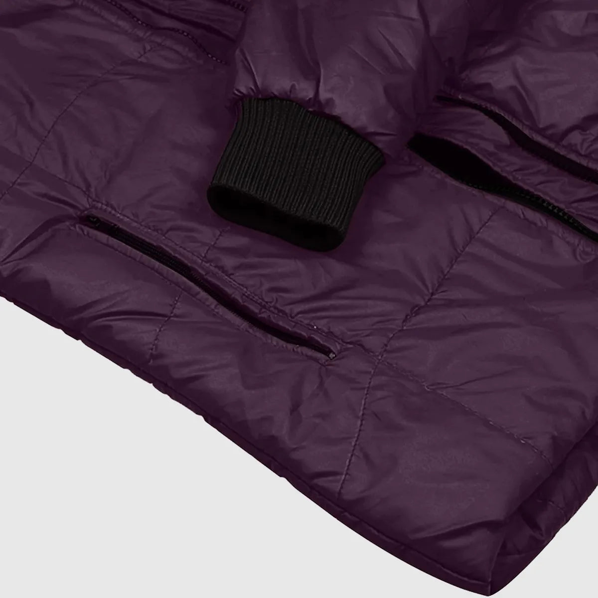 Close-up of a purple quilted jacket with a black zipper on a light gray background