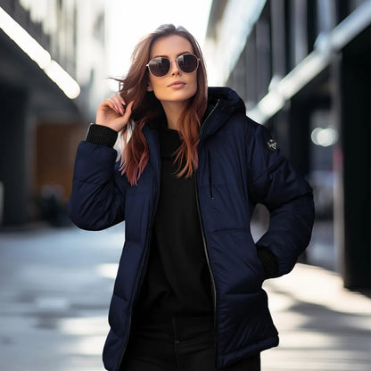 Woman wearing a navy blue puffer jacket and sunglasses on a city street.