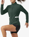 Person wearing a green athletic jacket and black shorts on a white background